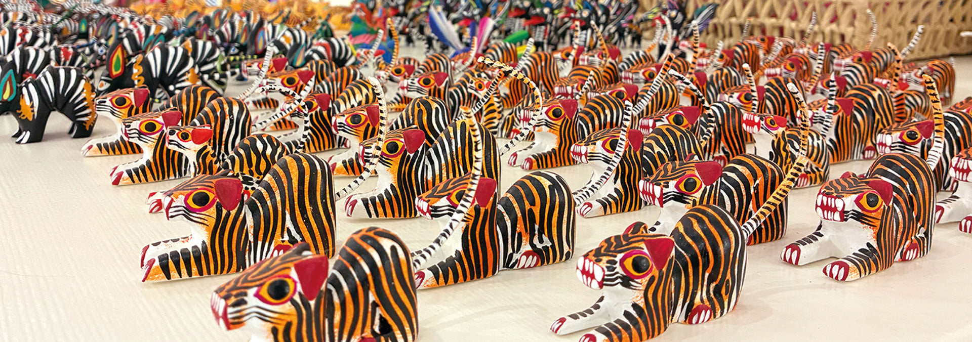 Hand-painted animal figurines crafted by Oaxacan artisans, featuring vibrant colors, whimsical designs, and traditional folk art techniques that celebrate Mexican cultural heritage.